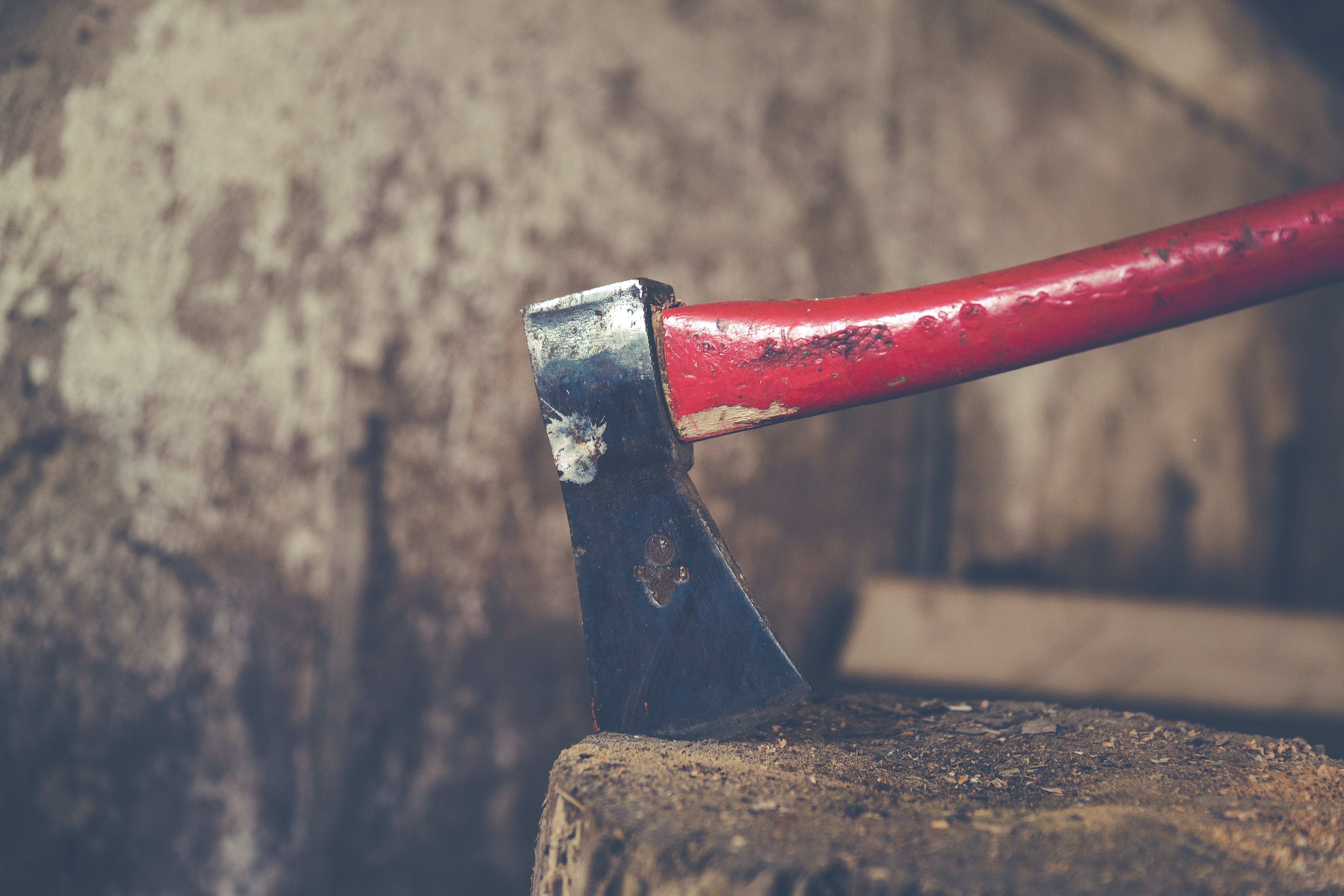 red and black axe on wood slab